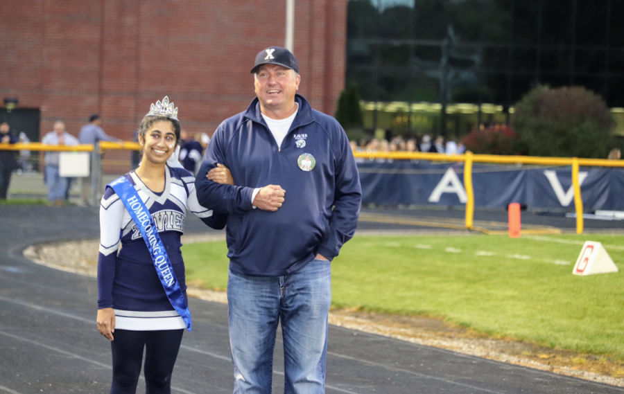 Homecoming Queen Sara Noronha walks with Homecoming King Kyle Moeders father, Tony Moeder, on the track during halftime. 