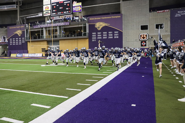 The varsity football team runs onto the field at the UNI-Dome before their game against Western Dubuque. 